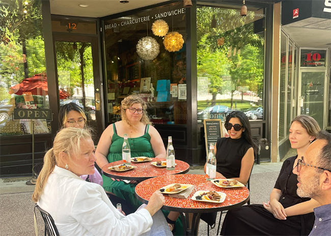 This is a picture of guests talking on the Fromagination outside patio with owner Ken Monteleone.